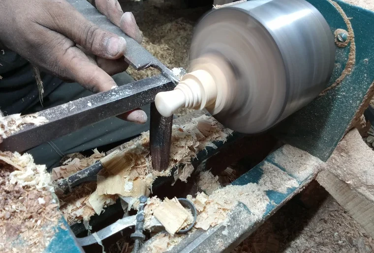 Craftsman prepare chess pieces on a machine